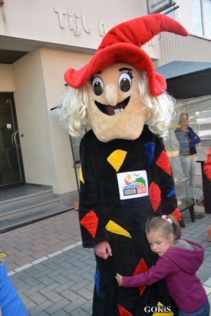 Stoisko delegacji z Gminy Wicko na festiwalu czarownic Heksenstoet w Beselare. Dziewczynka przytula się do maskotki czarownicy Erny.